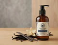 Goat milk lotion bottle with vanilla beans and a flower on a wooden surface